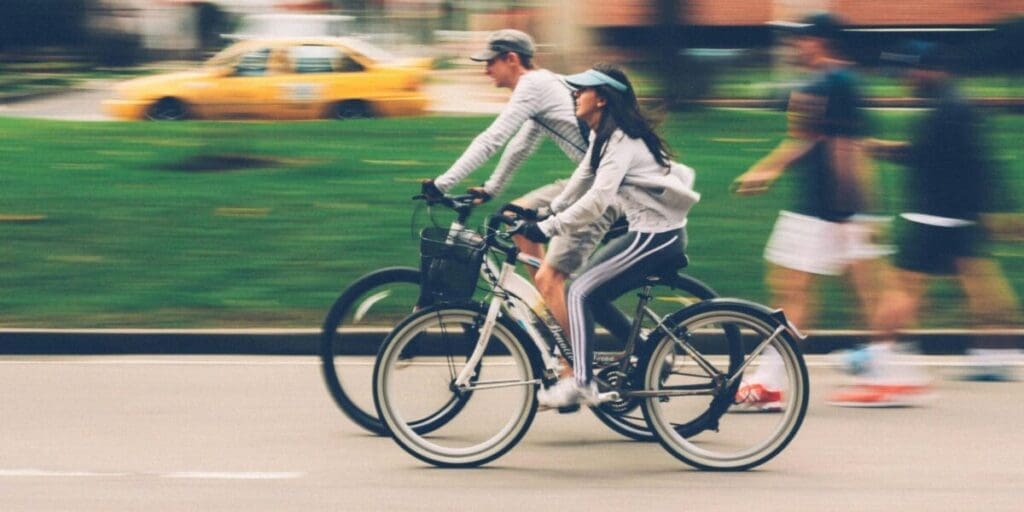 Man and Woman Riding on Bikes - Couple Commute on e-Bikes